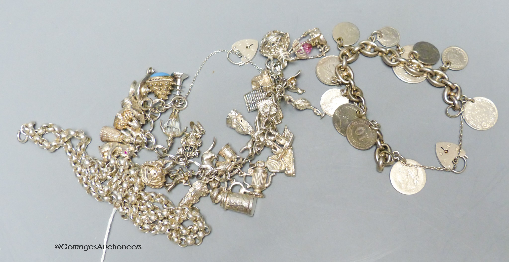 A silver charm bracelet, a silver necklace and a silver silver bracelet mounted with various coins, gross 224 grams.